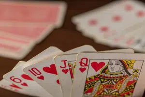 Should I reveal my hand? Playing cards tilted towards the viewer with others on the table